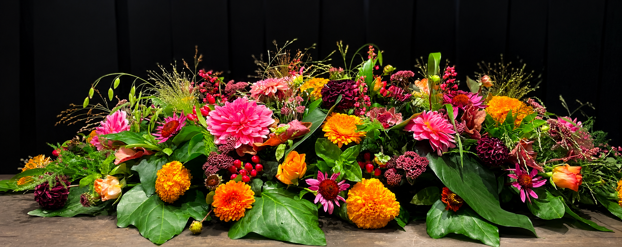 Kistepynt til begravelse er bundet i farverige nuancer og med blomster i forskellige størrelser. 
