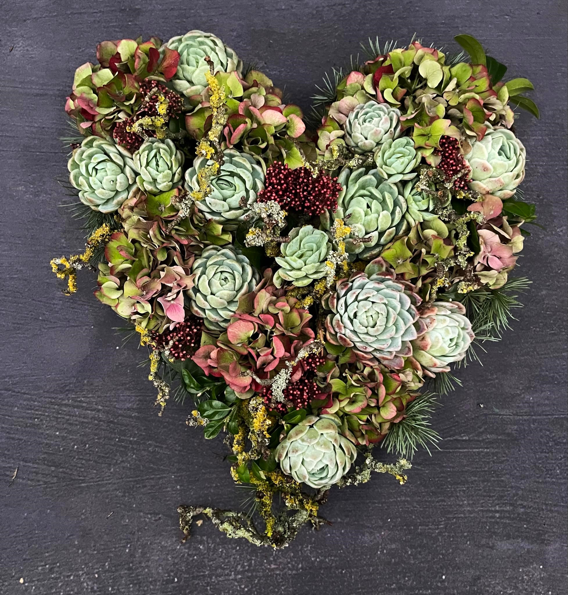 Begravelseshjerte i naturmaterialer som gran, hortensia, husløg og grene. 