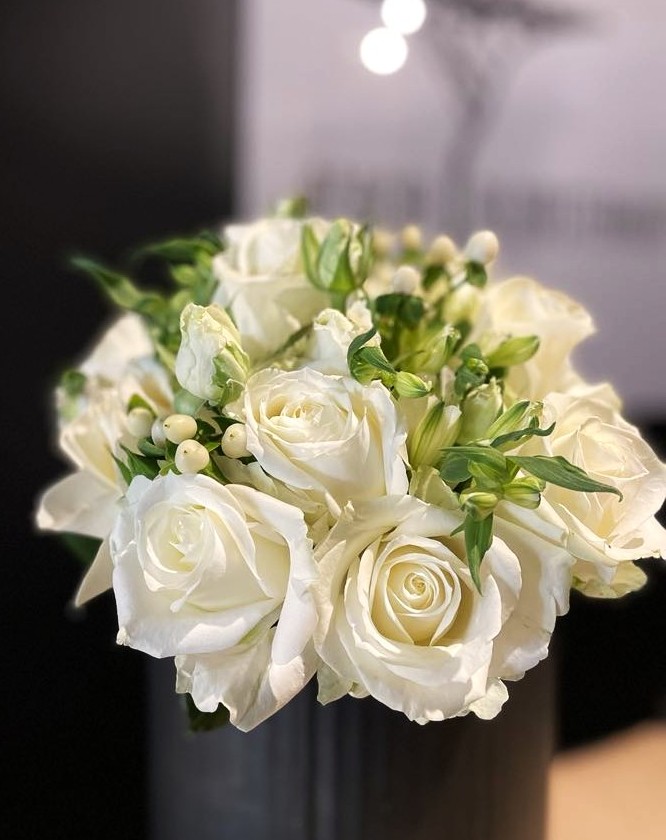 Tætbundet brudebuket med hvide roser og lysegrønne sommerblomster. 