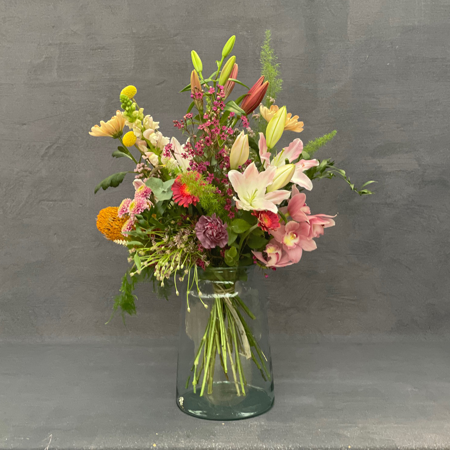 Høj buket med forårets store blomster i rosa, gule og varme nuancer. 