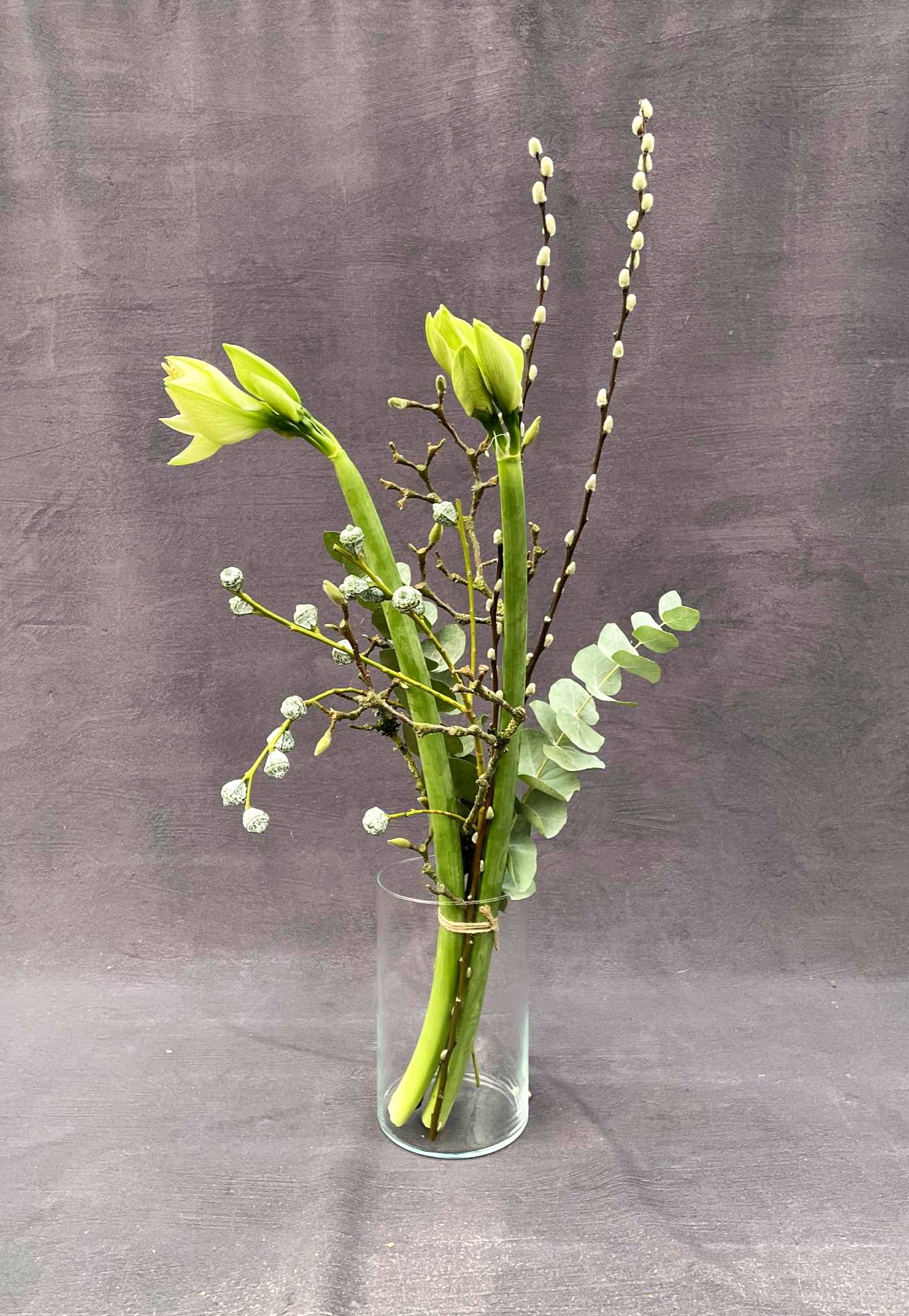 Høj buket bundet i et nordisk og enkelt udtryk, med grønne amaryllis og grene.