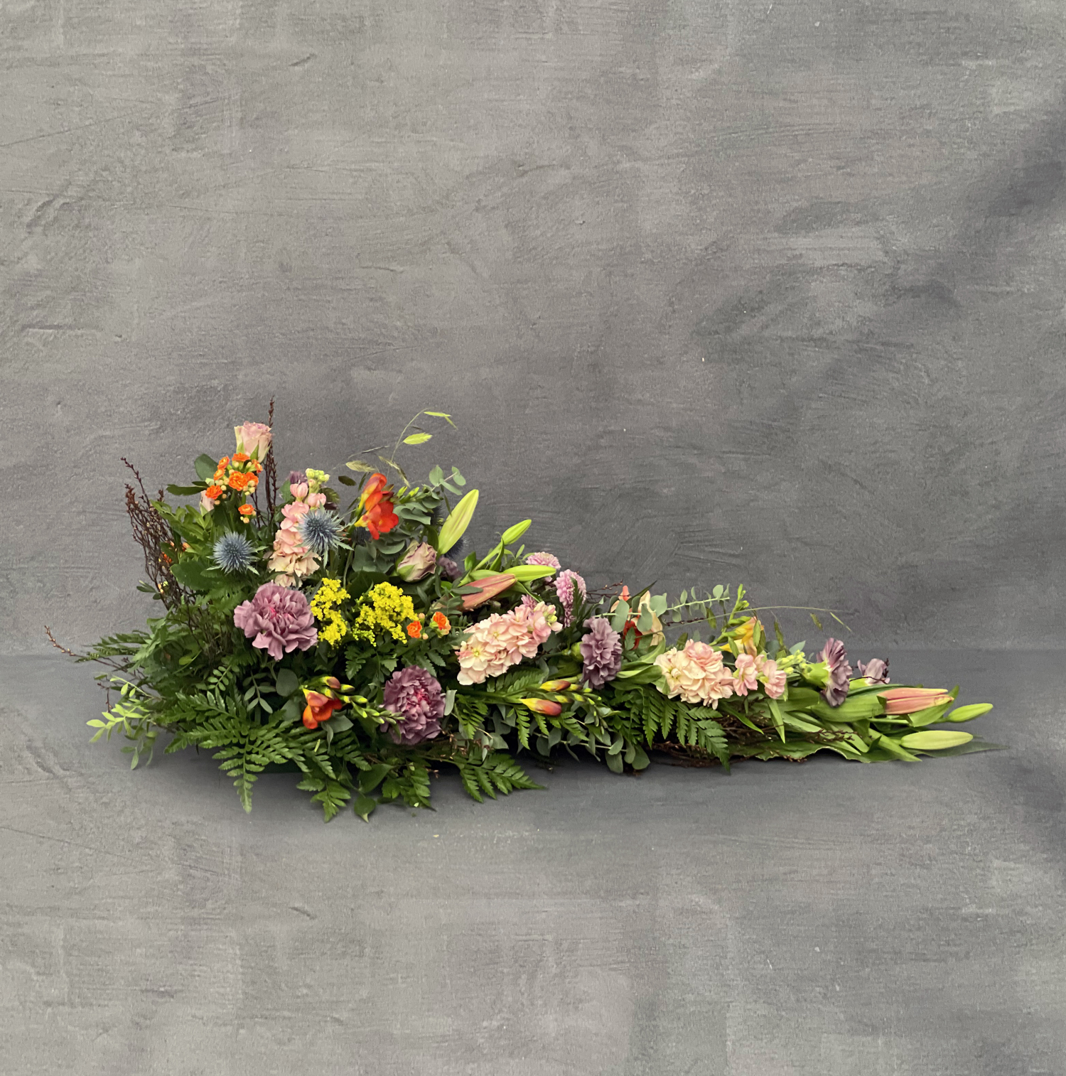 Bårebuket bundet i et luftigt udtryk med friske og farverige forårsblomster. 