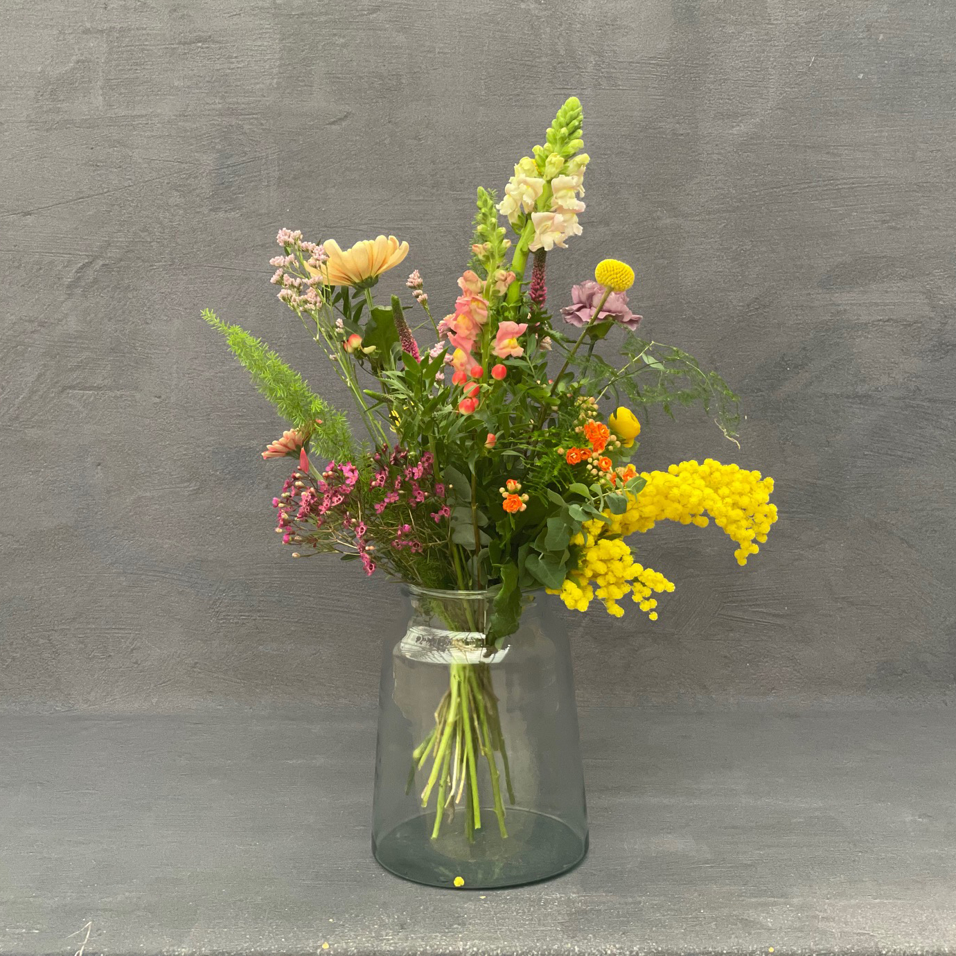 Høj og luftig buket bundet med farverige forårsblomster. 